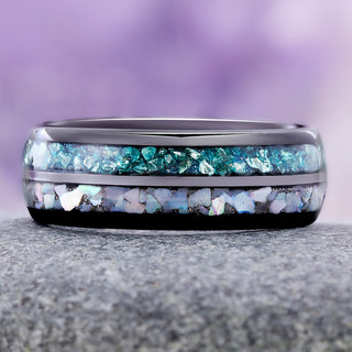 Crushed aquamarine and pearl men's band resting on gray stone, teal aquamarine channel above the iridescent pearl channel