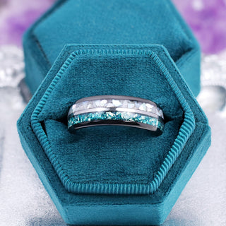 Crushed aquamarine and pearl men's wedding band presented in a teal velvet hexagon ring box