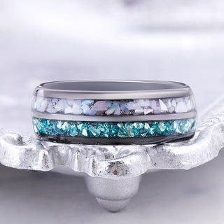 Aquamarine and pearl inlay black tungsten wedding band displayed on a silver tray