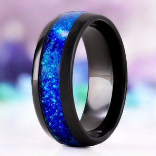 Crushed Blue Opal men's wedding band in polished black tungsten, 8mm, standing upright with the wide blue opal inlay catching the light