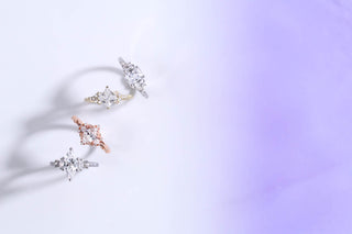 Three diamond earrings on a light purple background