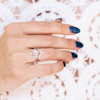 Hand wearing a silver ring with a white background