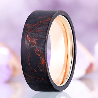 Standing view of the Emberwood men's wedding band showing copper veins through black wood and the rose gold tungsten interior