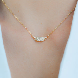 Model wearing the emerald cut moissanite necklace in 14K yellow gold vermeil at the collarbone