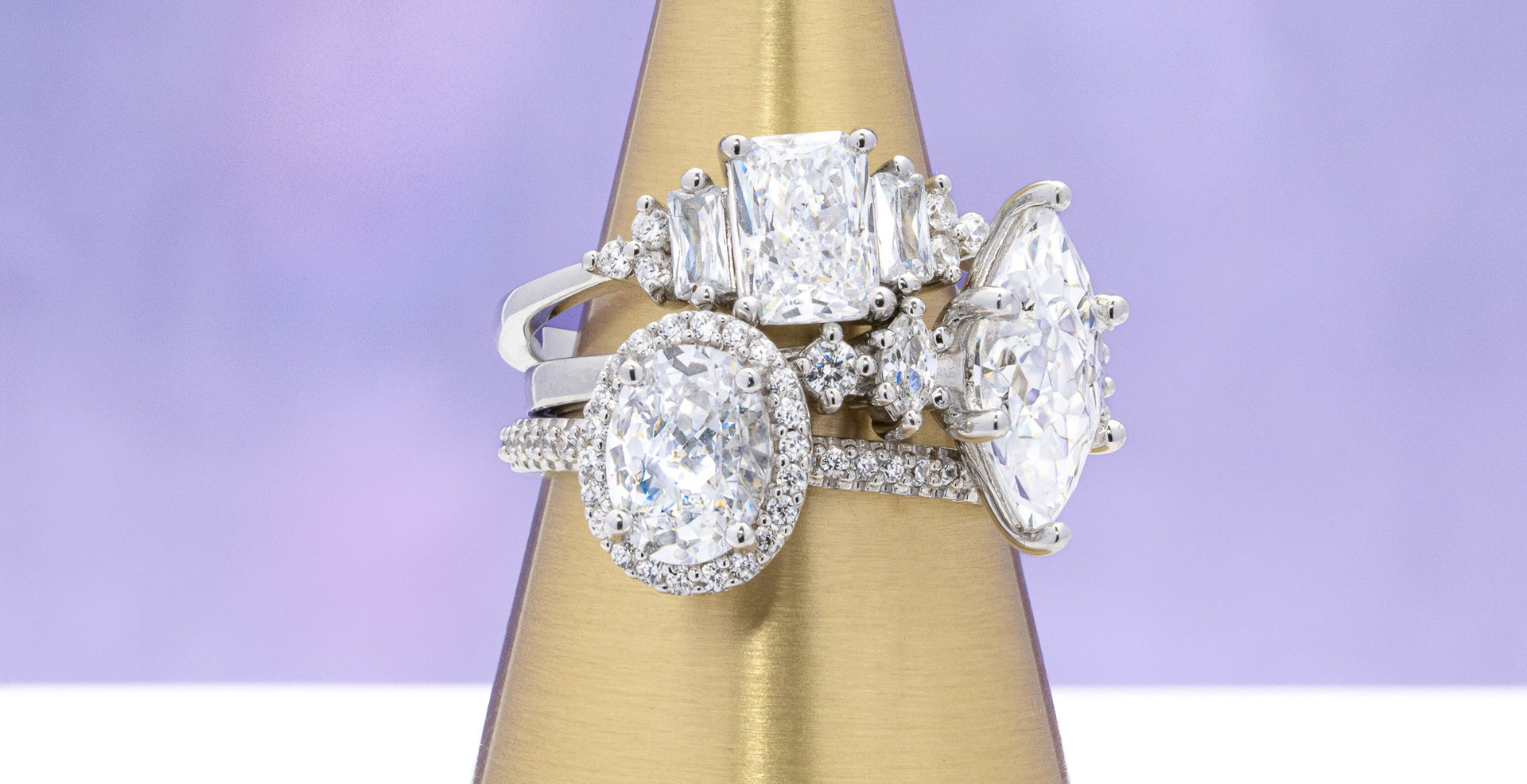 Diamond ring on a gold stand with a purple background