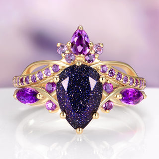 Gold ring with purple gemstones on a reflective surface with a blurred background