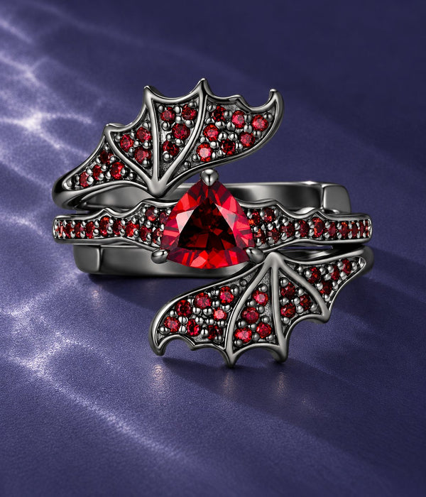 Natural Garnet Trillion Bat Ring Set in black ruthenium: bat wing ring with a trillion-cut garnet center and garnet pave wings, on blue satin, Aquamarise Halloween banner