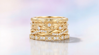 Gold ring with diamond accents on a gradient background