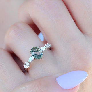Oval moss agate ring with opal worn on a model's hand