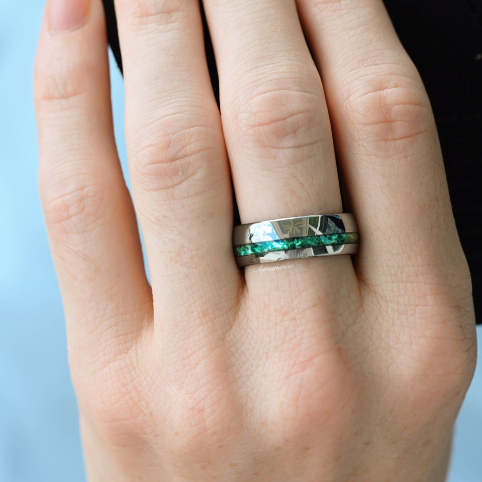 Crushed green moss agate wedding band in tungsten carbide by Aquamarise, worn on a hand
