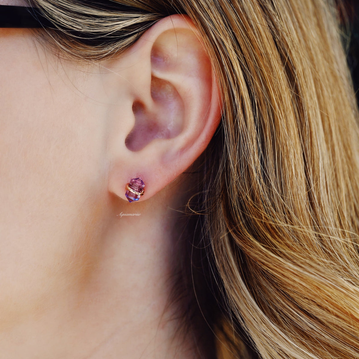 Minimalist Raw Alexandrite Stud Earrings in 14K Rose Gold Vermeil worn by model, featuring raw purple-hued alexandrite crystals set in polished rose gold by Aquamarise.