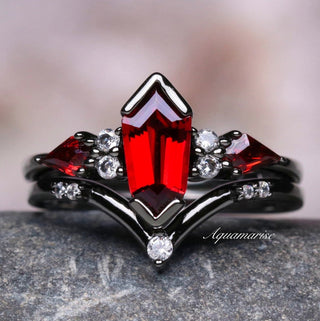 Elegant ring with red gemstone and diamond accents on a stone surface
