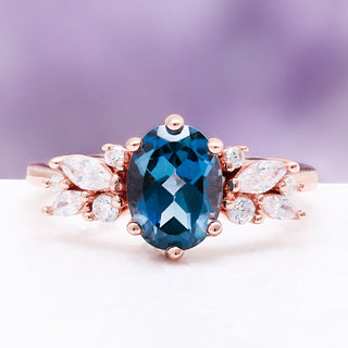 Front view of the Lily London blue topaz ring in 14K rose gold vermeil, oval London blue topaz flanked by marquise and round accents