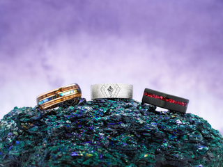 Three rings on a textured green surface with a purple gradient background