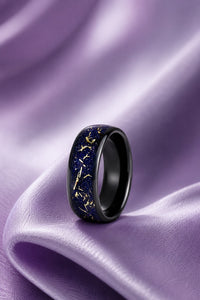 Men's black wedding band with a blue and gold sandstone inlay resting on lilac satin, Aquamarise vertical men's ring banner
