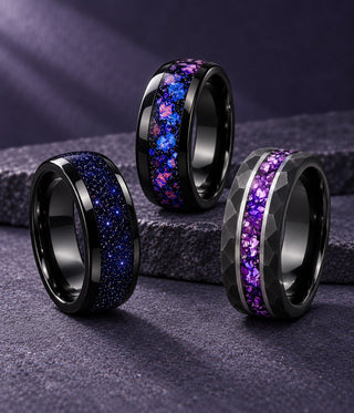 Three black men's wedding bands with blue sandstone, nebula and purple amethyst inlays on a purple stone ledge, Aquamarise banner