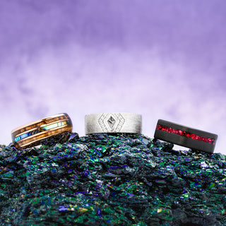 Three rings with unique designs on a textured surface with a purple gradient background