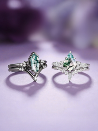 Two emerald rings with diamond accents on a purple background