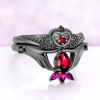 Angled view of the garnet Claddagh ring set, showing the black onyx beaded crown band and the three lab-grown ruby marquises below the pear garnet