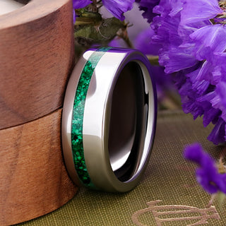 Silver tungsten 8mm men's band with an offset natural malachite inlay, leaning against a wooden ring box