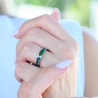 Natural malachite inlay tungsten wedding band worn on a model's hand