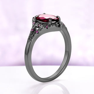 Side profile of the Nerida lab-grown ruby ring in black ruthenium, the oval stone held in four prongs above the carved gallery