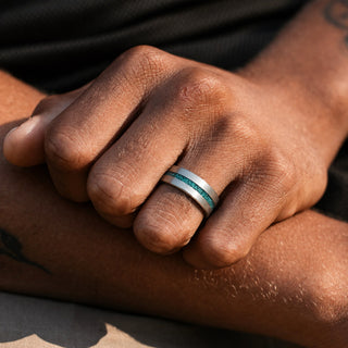 Man wearing the 8mm Off-Set Moss Agate men's wedding band in brushed tungsten, crushed moss agate inlay set off-centre in the matte band