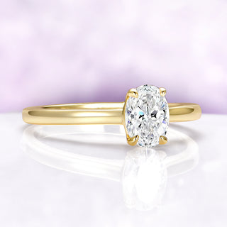 Gold ring with a large diamond on a light purple background