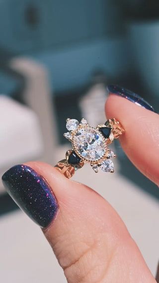Video of the Aurelia black onyx engagement ring in solid 14K yellow gold by Aquamarise held in sunlight, oval center stone with black onyx accents