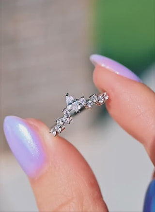Hand holding silver wedding band with marquise and round diamond accents