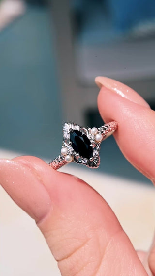 Video of the Arwen Black Onyx & Pearl Ring in Sterling Silver by Aquamarise held in sunlight, marquise black onyx framed by pearls
