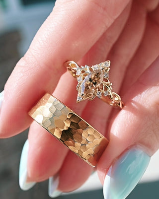 Hand holding champagne moissanite couples engagement ring set