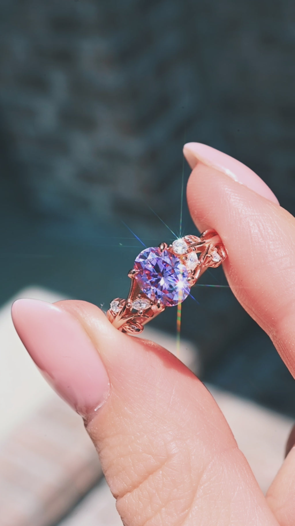 Product video of the Lavender Moissanite Leaf Engagement Ring in Solid 14K Rose Gold by Aquamarise, showing the lavender moissanite in a leaf-detailed rose gold setting.