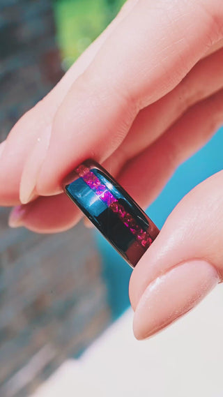 Video of the off-set crushed ruby black tungsten band in motion, showing the magenta-red inlay catch the light