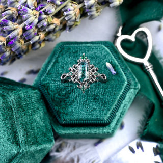 Ravenna Hexagon Moss Agate & Simulated Emerald Ring in Black Ruthenium in a teal velvet ring box with lavender