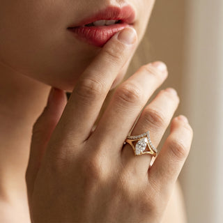 Close-up of a hand wearing a diamond ring with a blurred background