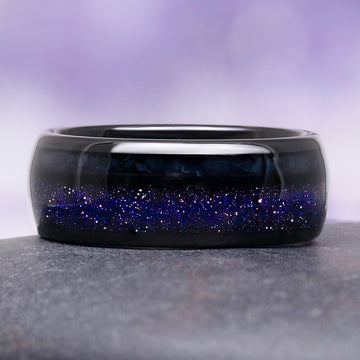 Black ring with blue glittery interior on a gray surface