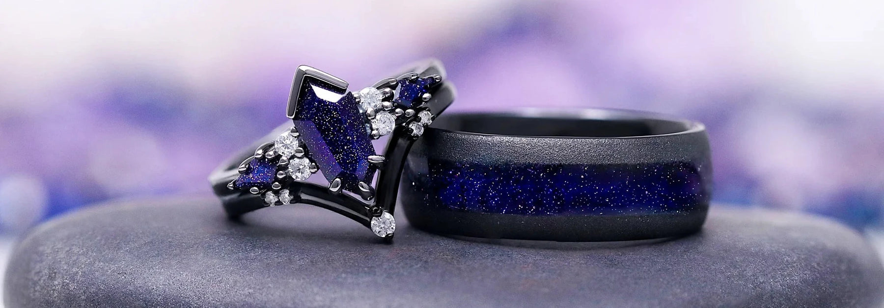 Two rings with blue stones on a gray stone surface