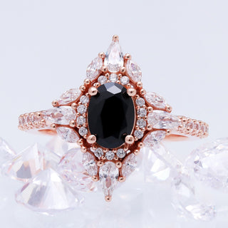 Stella black onyx ring in 14K rose gold vermeil shown beside clear crystals, showing the pave band and marquise halo