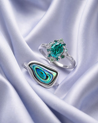 Teal gemstone halo ring and abalone shell ring in sterling silver on lilac satin, Aquamarise vertical collection banner