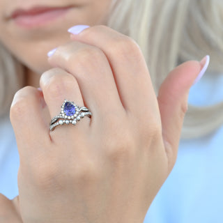 Teardrop tanzanite engagement ring set worn on a model's hand