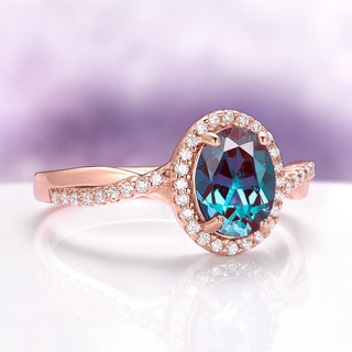 Rose gold ring with a blue gemstone on a white surface with a purple gradient background