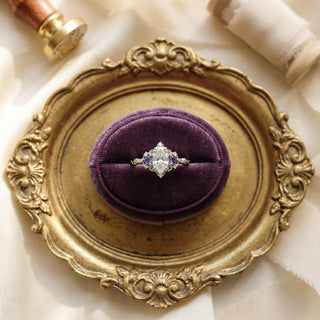 Ring on a purple cushion in an ornate gold ring box