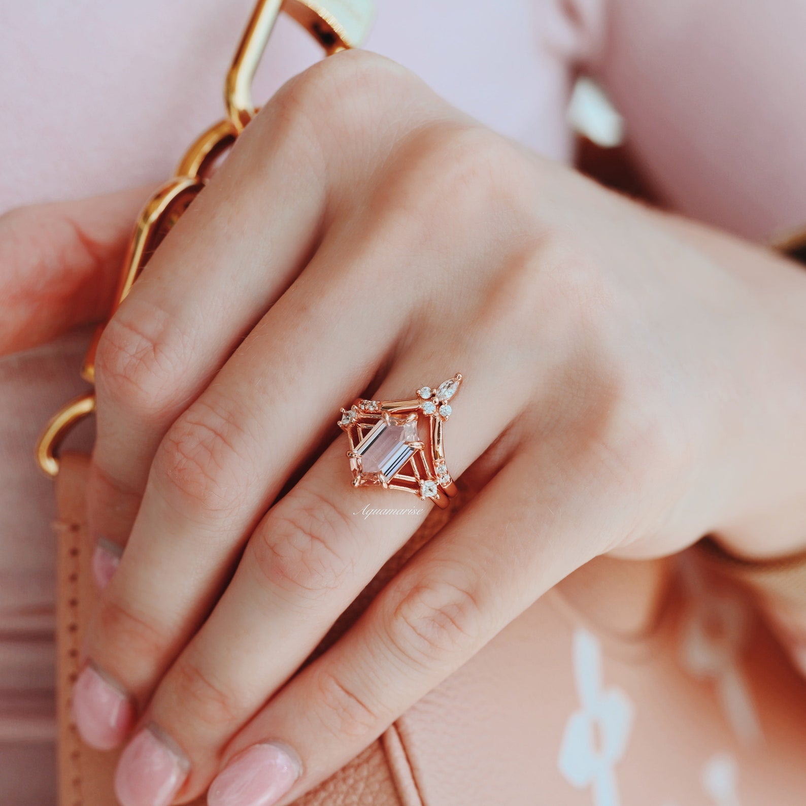 Rose gold vintage-inspired ring with a large center gemstone, worn on a model's hand