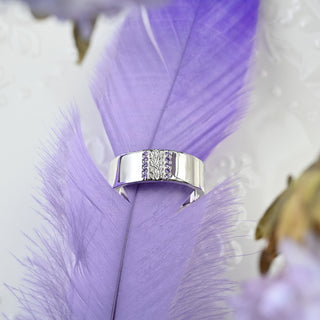 Viridian Leaf & Amethyst Men's Wedding Band in Sterling Silver (8mm) resting on a purple feather
