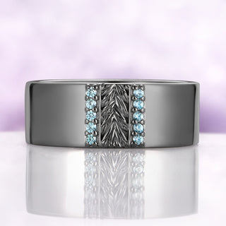 Mens 8mm black ruthenium wedding band with a carved leaf panel and two channels of natural aquamarine, front view