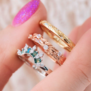 Three wedding gold rings with different designs on a blurred background