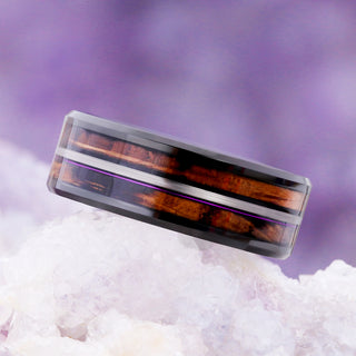 Angled view of the black tungsten men's band with double whiskey barrel wood inlays and a purple fishing line accent