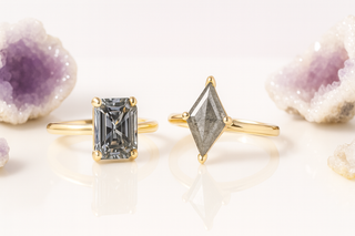 Two gold rings with diamond-shaped gemstones on a light background