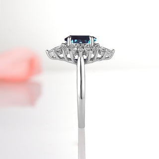 Aurora Alexandrite Ring - Sterling Silver by Aquamarise featuring an oval alexandrite center set in a rhodium-finished band with a halo of sparkling simulated diamonds in a vintage-inspired design.
